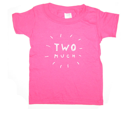 A pink t-shirt with the text "TWO MUCH" printed on it.