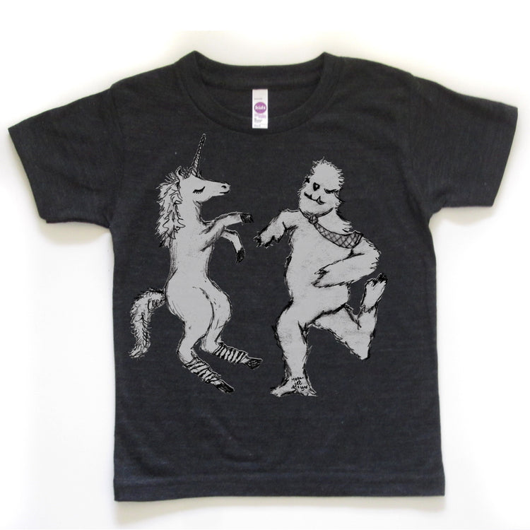 A black t-shirt with a graphic design depicting a unicorn and a creature, possibly a dragon or monster, dancing together.