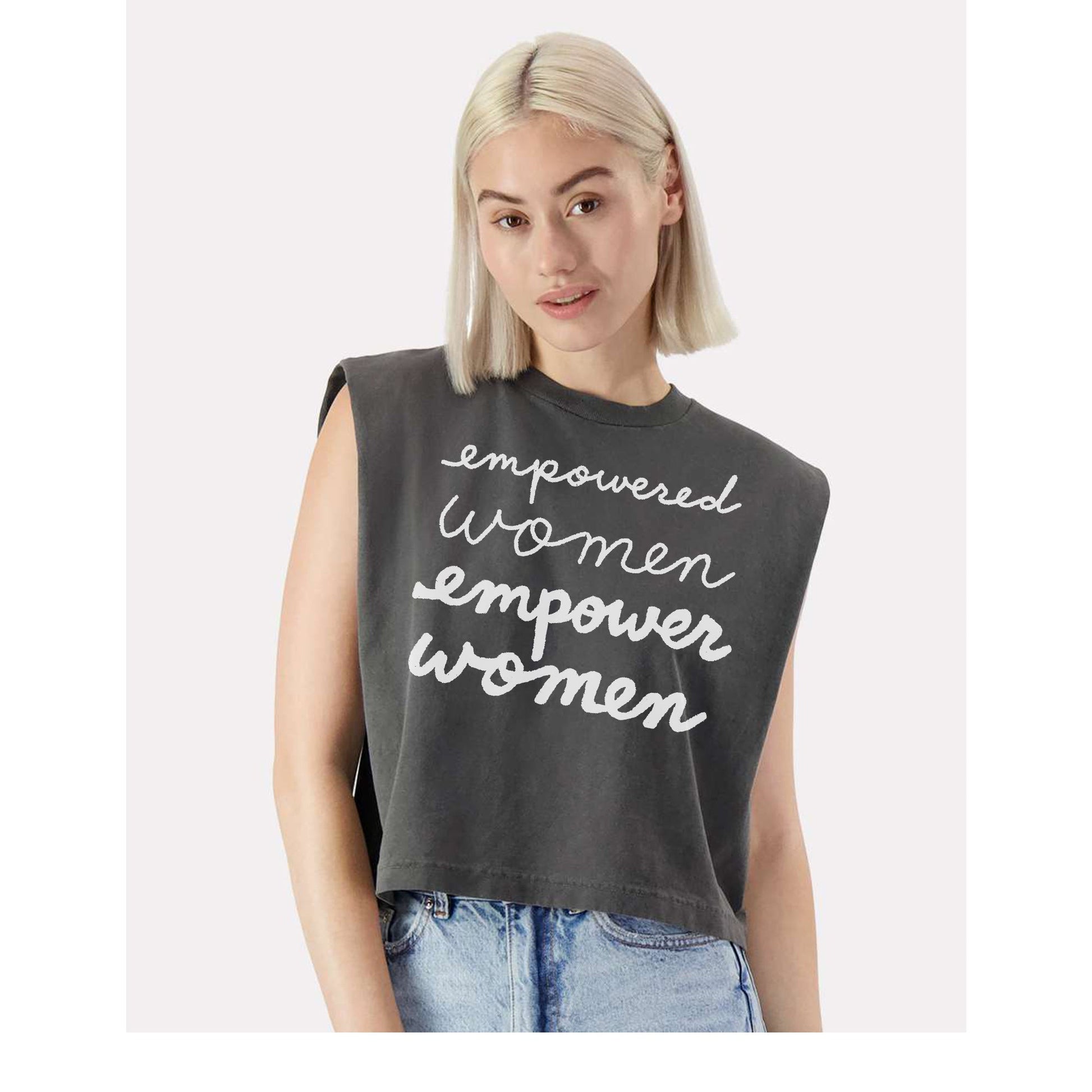 A young woman with blonde hair wearing a gray sleeveless top with the text "empowered women" printed on it.