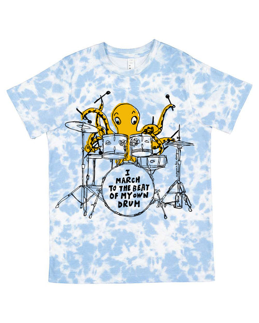 A blue and white tie-dye t-shirt with an illustration of an octopus playing a drum set and the text "I march to the beat of my own drum" printed on it.