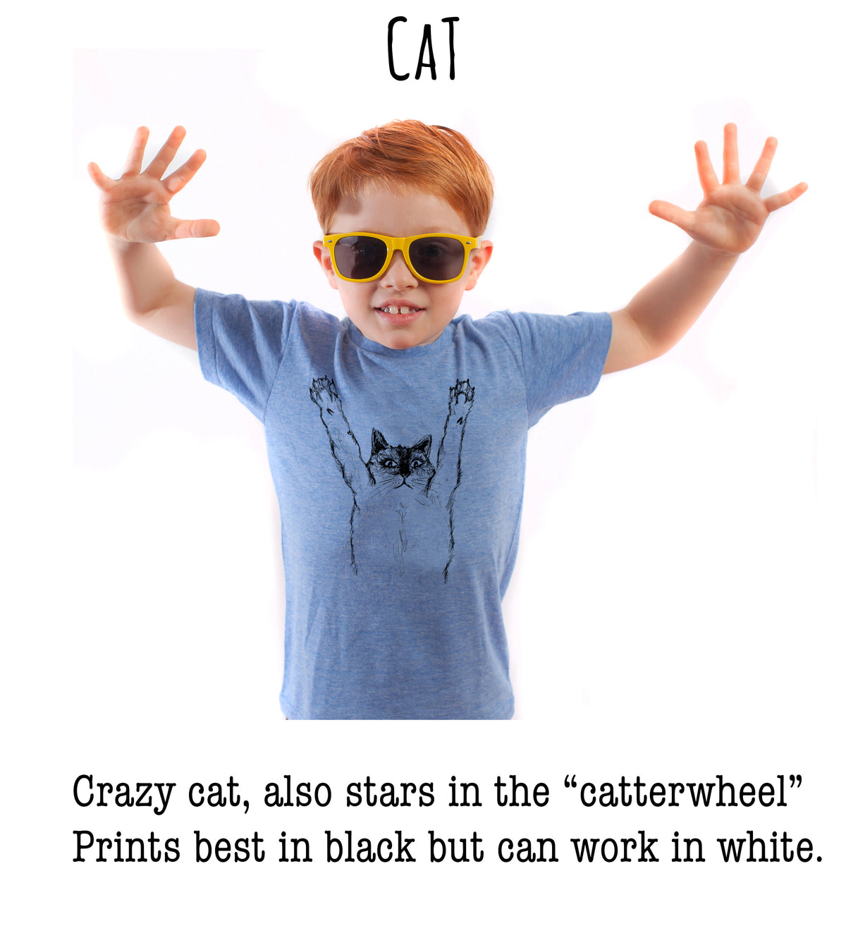 A young boy with red hair wearing a blue shirt with a cat graphic and yellow sunglasses, smiling and making a "cat" gesture with his hands.