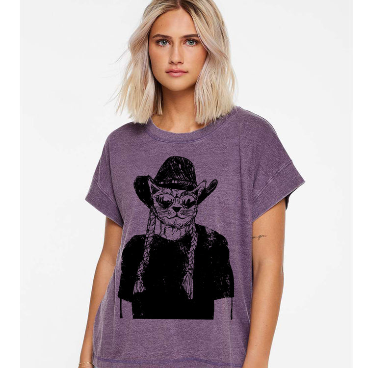 A woman wearing a purple t-shirt with a graphic of a cat wearing a cowboy hat.