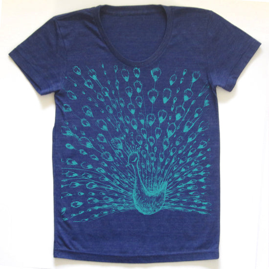 A blue t-shirt with a graphic design depicting a peacock spreading its feathers.