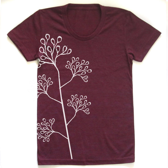 A burgundy-colored t-shirt with a white line drawing of a plant or flower on the front.