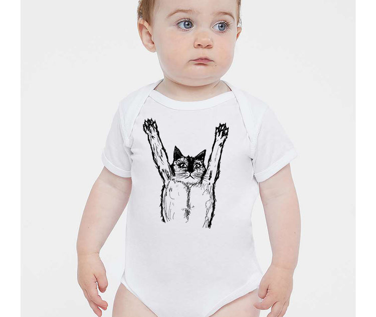 A baby wearing a white onesie with a black cat graphic on it.