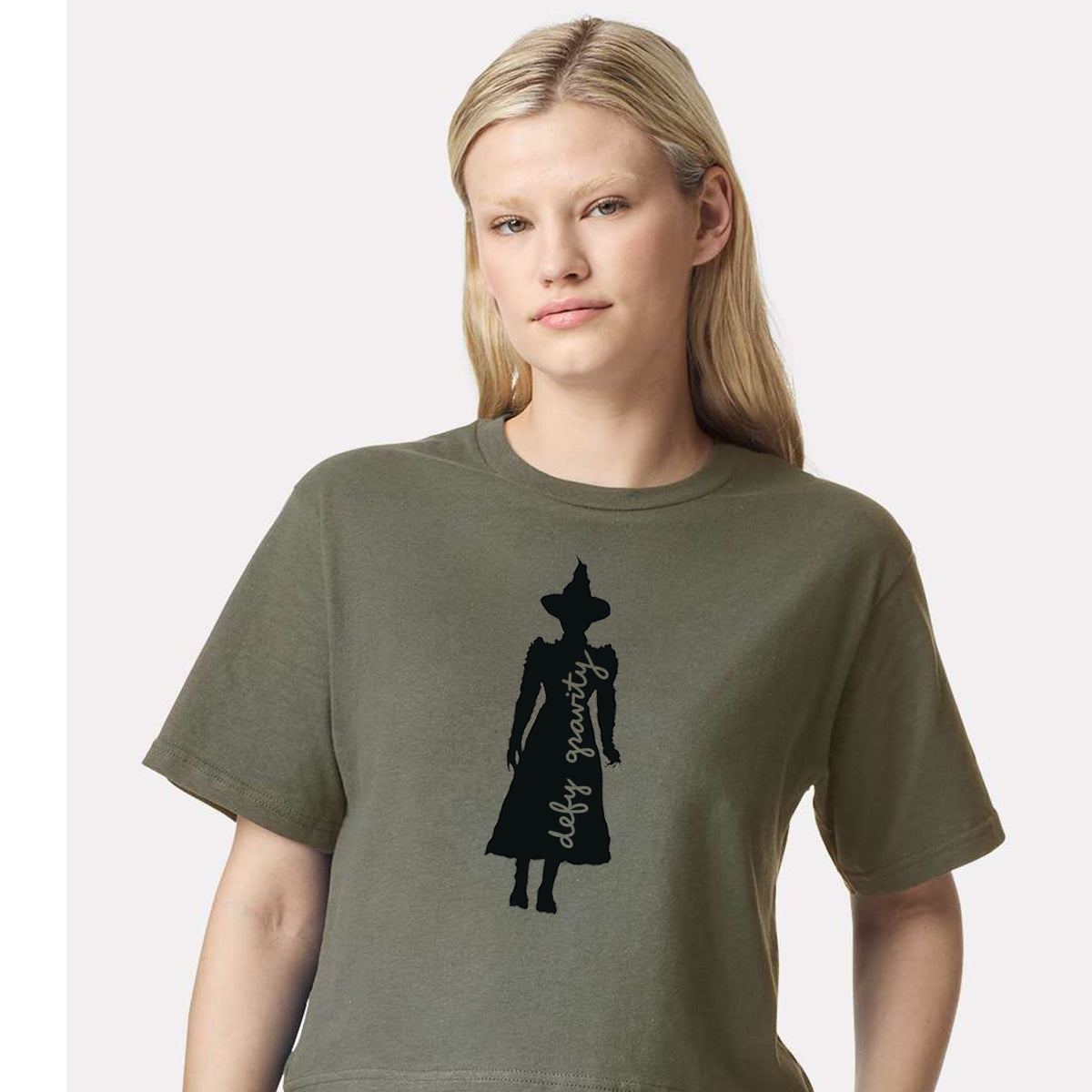 A woman wearing a green t-shirt with a silhouette of a person wearing a hat printed on it.