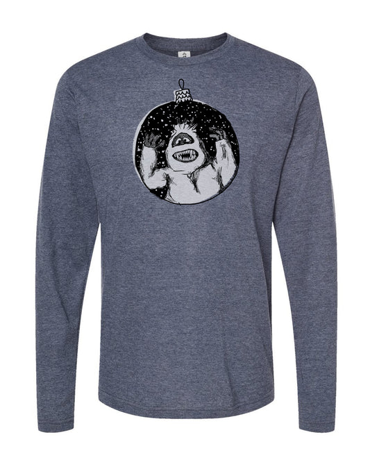 A gray long-sleeved t-shirt with a graphic design depicting a large, menacing-looking creature with sharp teeth and claws, surrounded by a circular frame with a starry background.