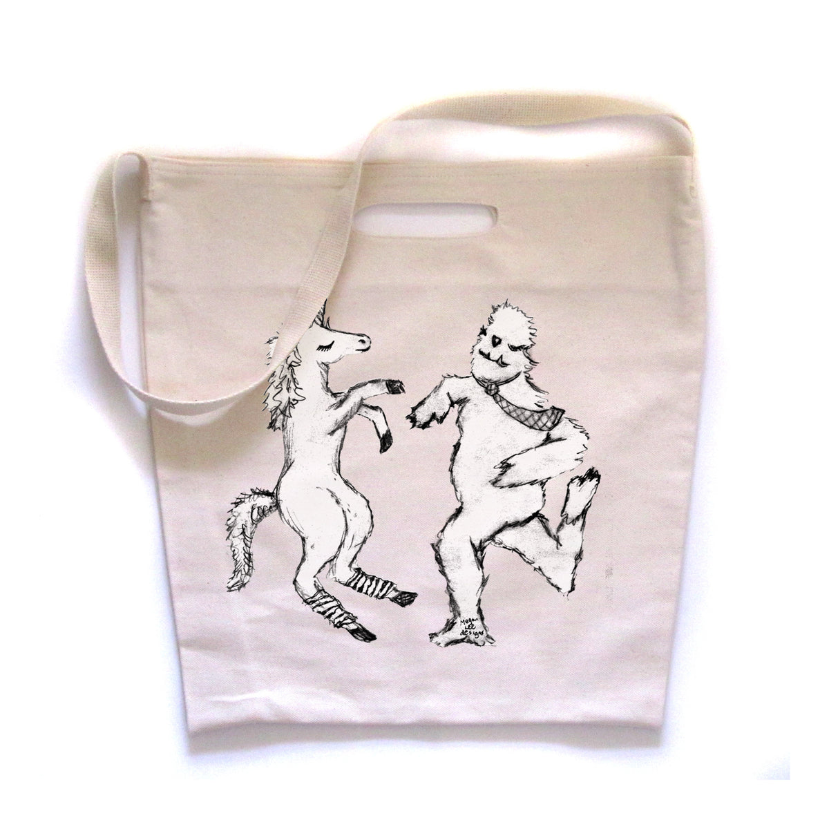 a white tote bag with a black and white illustration of a unicorn and a bear dancing together.