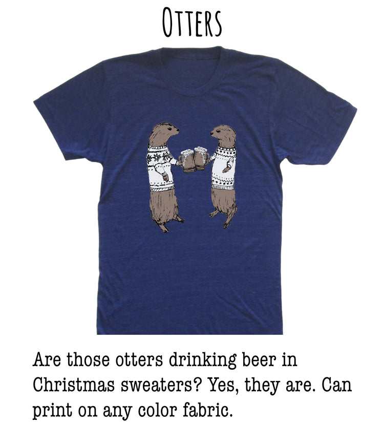 A blue t-shirt with a graphic of two otters wearing Christmas sweaters and holding beer mugs, along with text that asks "Are those otters drinking beer in Christmas sweaters? Yes, they are. Can print on any color fabric."