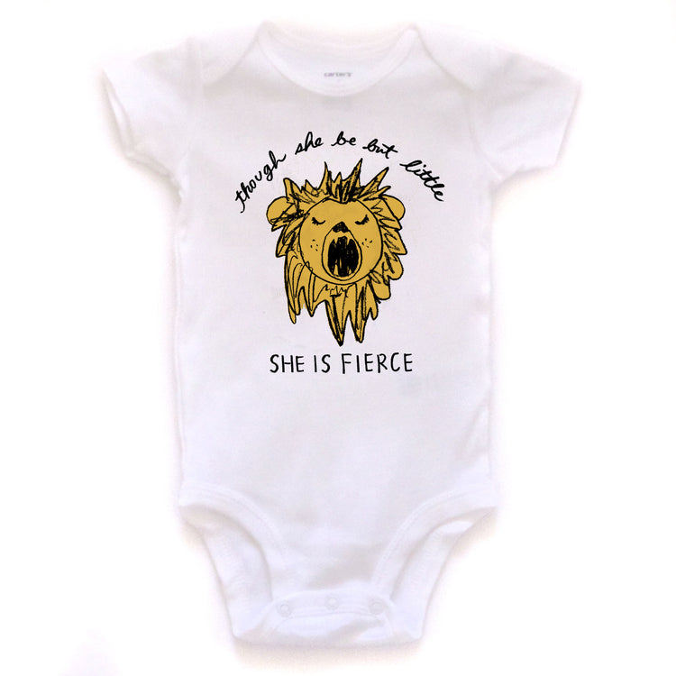A white baby onesie with a yellow lion graphic and the text "She is fierce" printed on it.