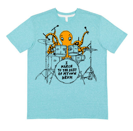 A light blue t-shirt with an illustration of an orange octopus playing a drum set and the text "I MARCH TO THE BEAT OF MY OWN DRUM" printed on it.