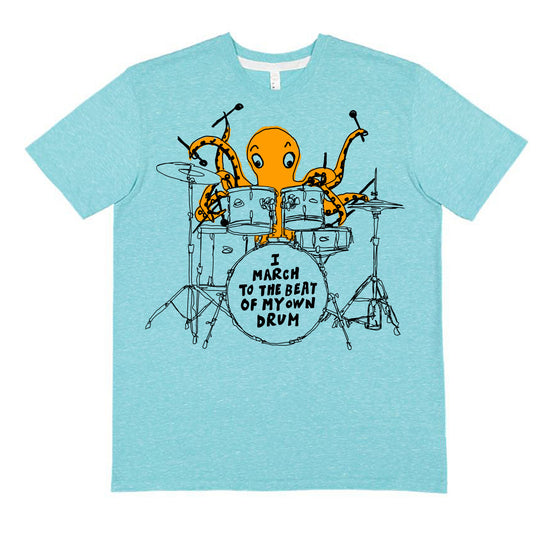 A light blue t-shirt with an illustration of an orange octopus playing a drum set and the text "I MARCH TO THE BEAT OF MY OWN DRUM" printed on it.