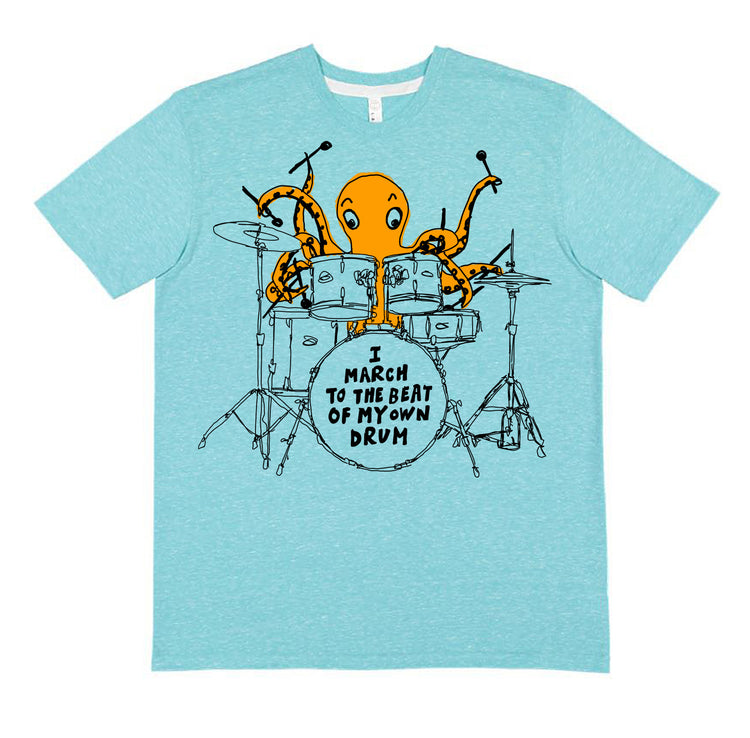A light blue t-shirt with an illustration of an orange octopus playing a drum set and the text "I MARCH TO THE BEAT OF MY OWN DRUM" printed on it.