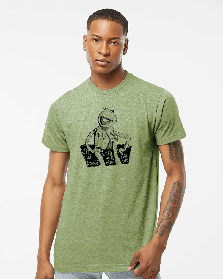 A man wearing a green t-shirt with a graphic of Kermit the Frog sitting on a bench.