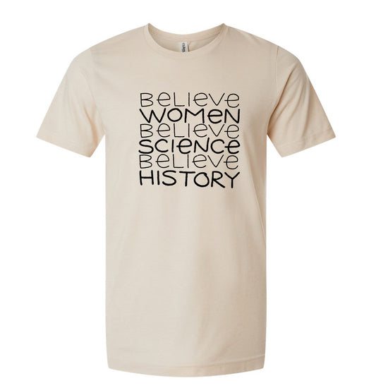 A beige t-shirt with the text "Believe Women Believe Science Believe History" printed on it in a bold, black font.