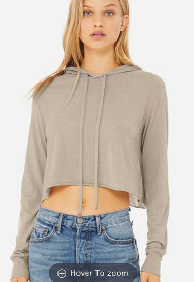 A young woman with long blonde hair wearing a gray hoodie and blue jeans.