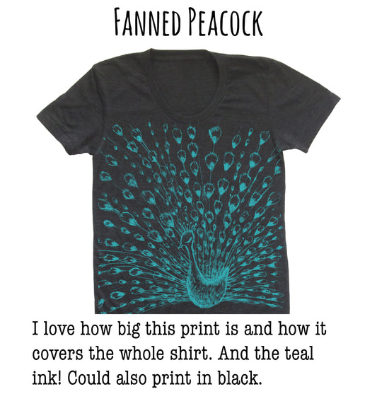 A black t-shirt with a large, teal-colored peacock design printed on it.