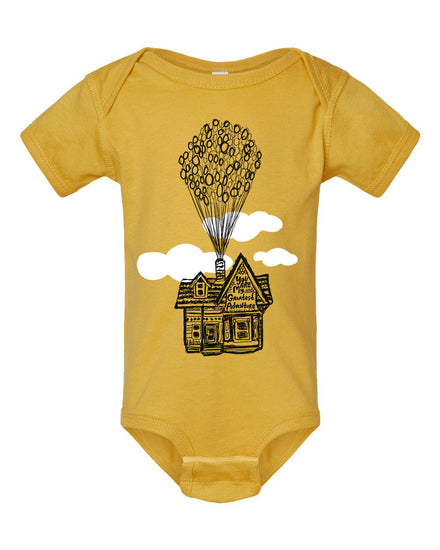 A yellow baby onesie with a graphic of a house and balloons floating above it.