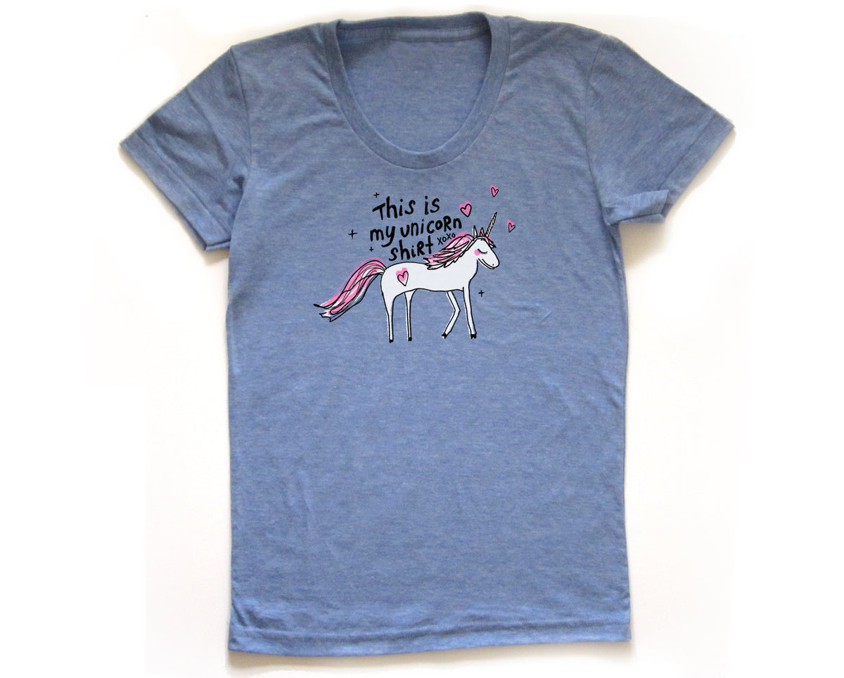 A blue t-shirt with a graphic of a white unicorn and the text "This is my unicorn shirt" printed on it.