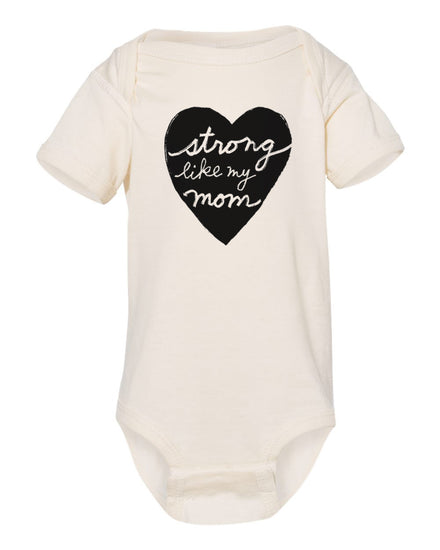 A cream-colored baby onesie with a black heart-shaped graphic and the text "Strong like my mom" printed on it.