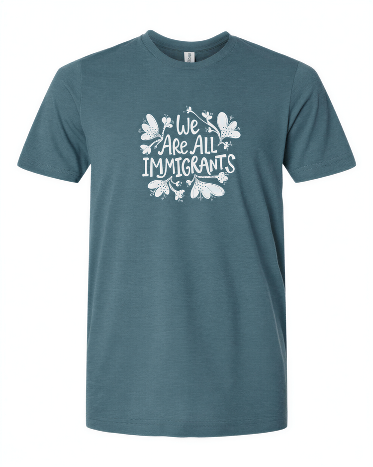 A teal-colored t-shirt with the text "We Are All Immigrants" printed on it in white.