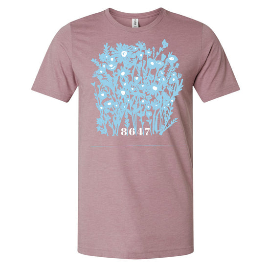 A pink t-shirt with a graphic design depicting a blue floral pattern.