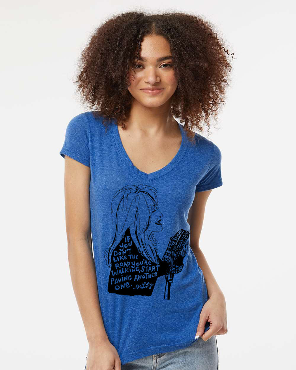 A young woman with curly hair wearing a blue t-shirt with a graphic design and text printed on it.