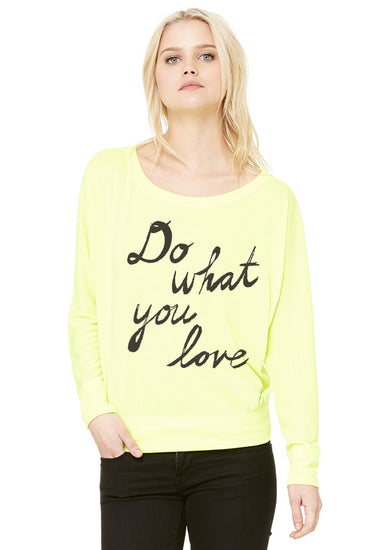 A woman wearing a yellow long-sleeved top with the text "Do what you love" printed on it.