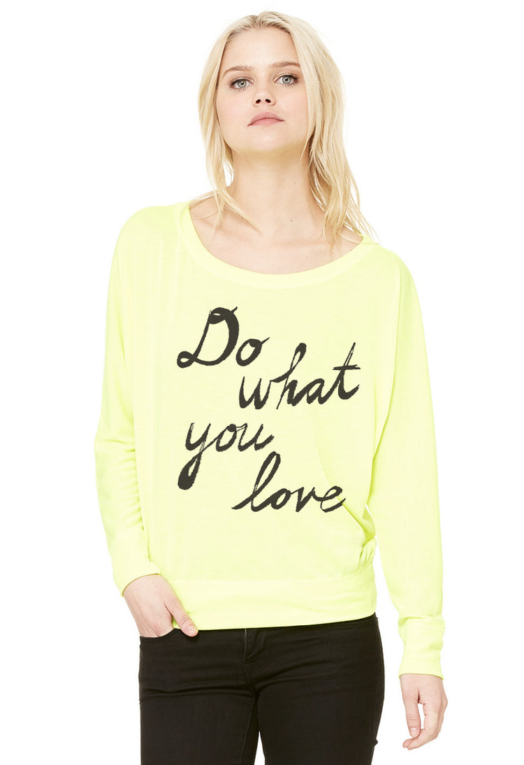 A woman wearing a yellow long-sleeved top with the text "Do what you love" printed on it.