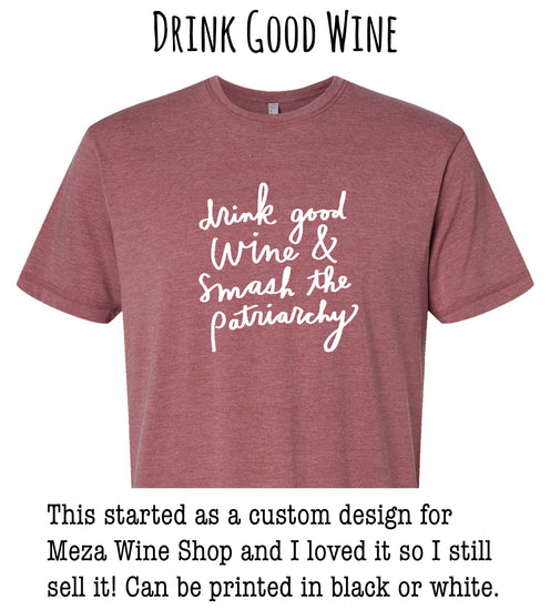 a red t-shirt with white text that reads "drink good wine & smash the patriarchy". The t-shirt is described as a custom design for Meza Wine Shop, and the person who created it loved it so much that they still sell it in black or white.