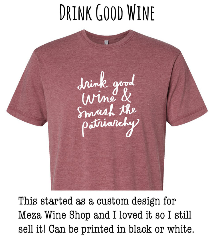 a red t-shirt with white text that reads "drink good wine & smash the patriarchy". The t-shirt is described as a custom design for Meza Wine Shop, and the person who created it loved it so much that they still sell it in black or white.