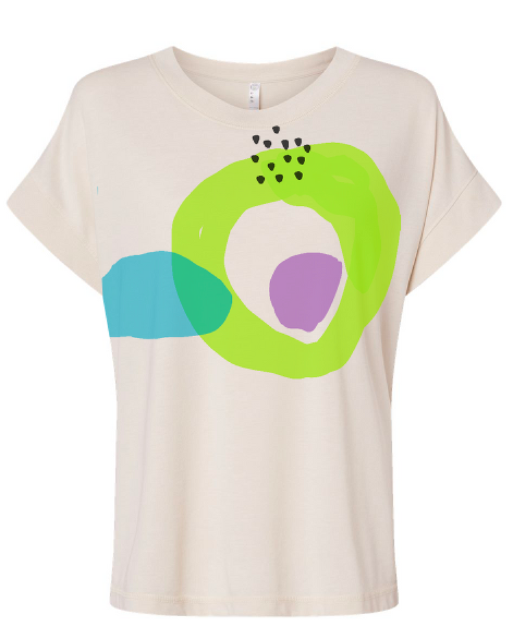 The image is a white t-shirt with a colorful abstract design featuring green, blue, and purple shapes.
