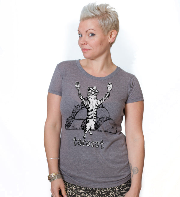 A woman wearing a gray t-shirt with a graphic of a cat holding a taco and the word "tacocat" printed on it.