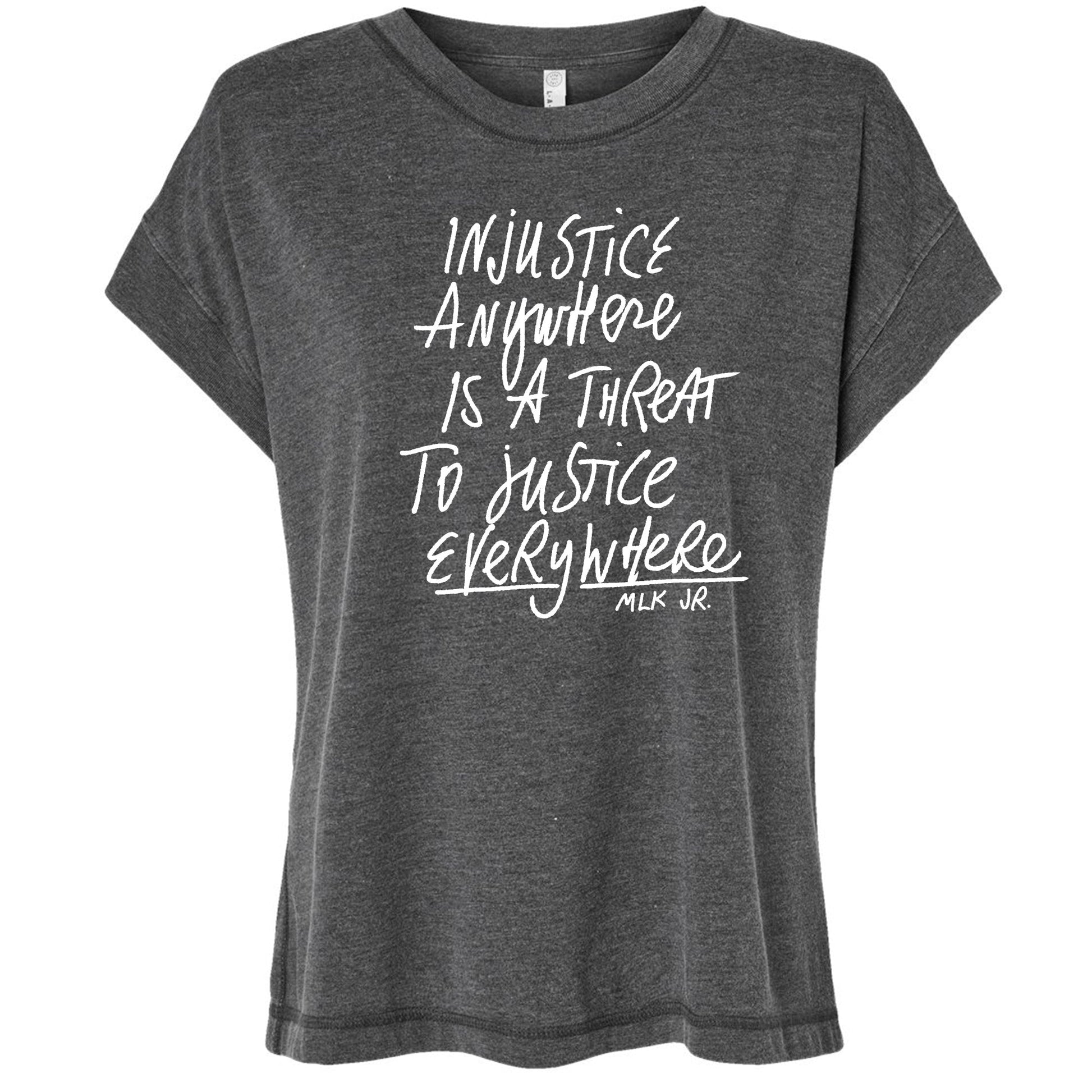 a gray t-shirt with white text printed on it. The text reads "Injustice anywhere is a threat to justice everywhere" and includes the name "MLK Jr."