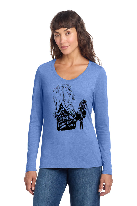 A woman wearing a blue long-sleeved shirt with a graphic design on it.