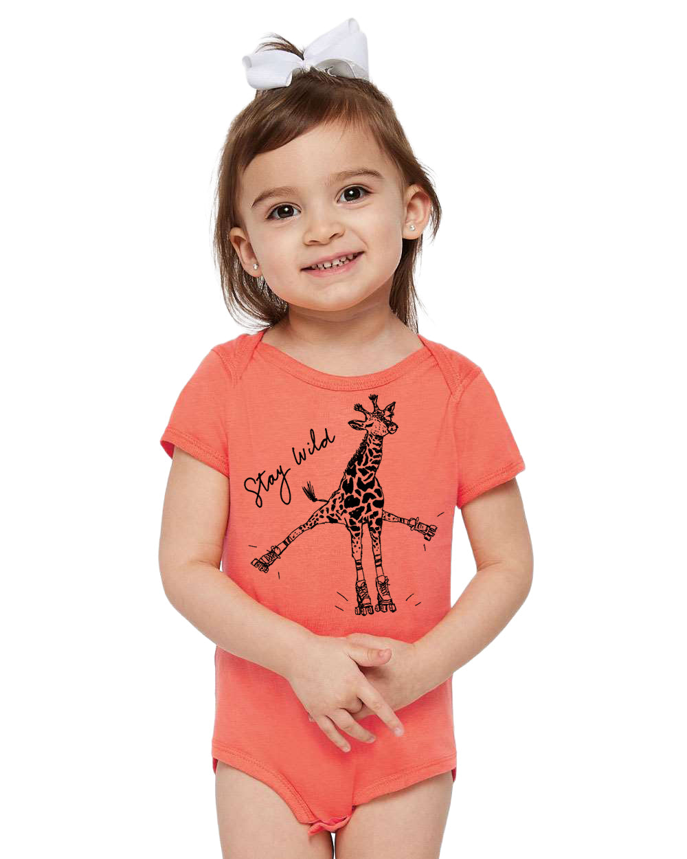 A young girl wearing a bright orange onesie with a giraffe graphic and the text "Stay wild" printed on it.