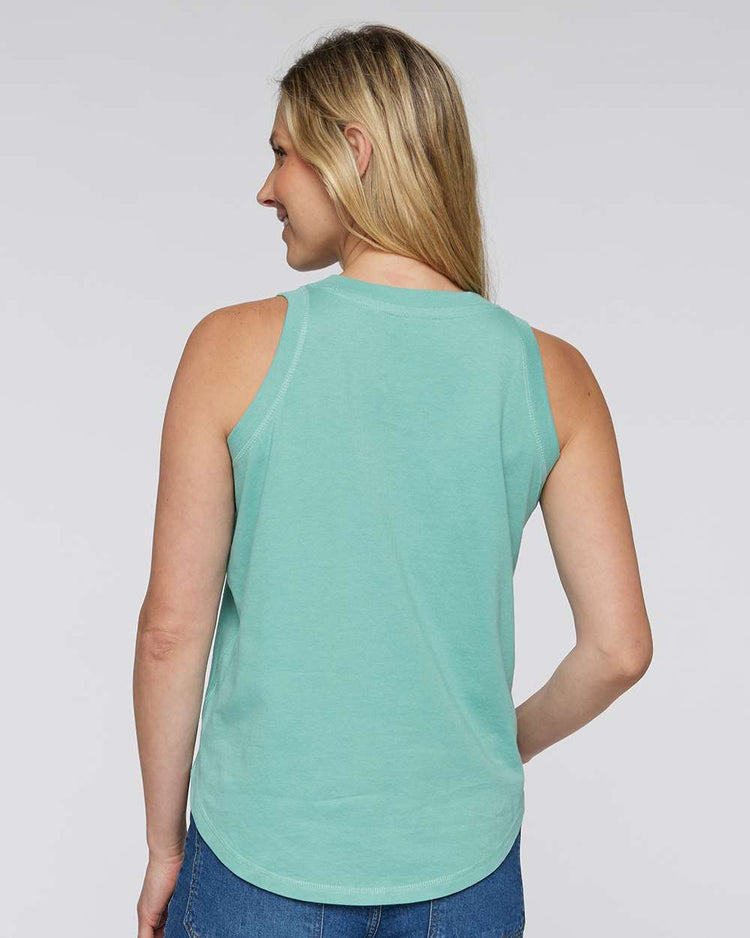 A woman with blonde hair wearing a mint green sleeveless top is facing away from the camera, with her back turned.