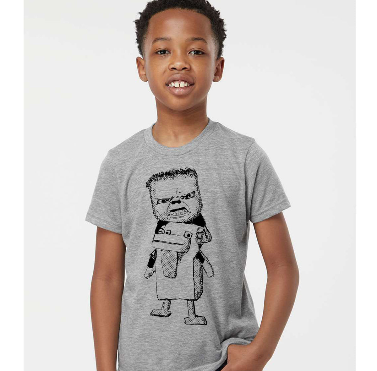 A young boy wearing a gray t-shirt with a cartoon character printed on it.