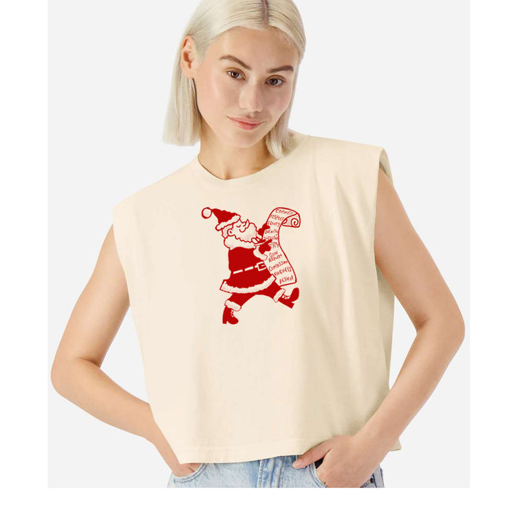 A woman wearing a beige sleeveless top with a red graphic of Santa Claus on it.