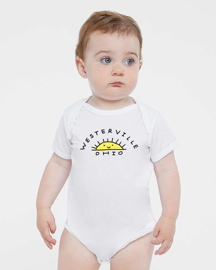 A baby wearing a white onesie with the text "WESTERVILLE OHIO" printed on it.
