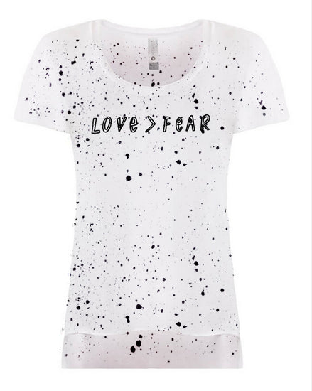 A white t-shirt with black splatter-like patterns covering the entire front.