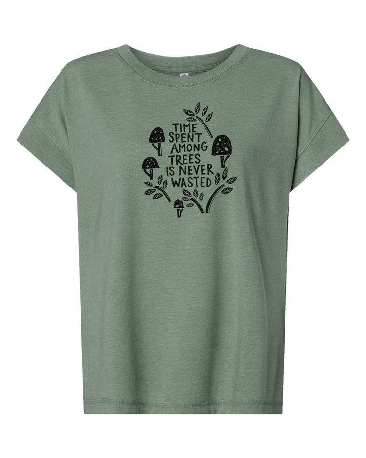 A green t-shirt with a graphic design featuring a mushroom and leaves, along with the text "Time spent among trees is never wasted".