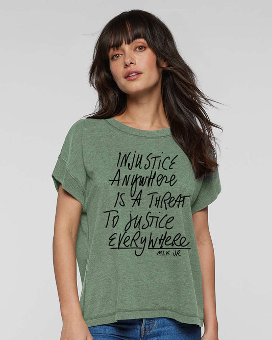a woman wearing a green t - shirt with black writing on it