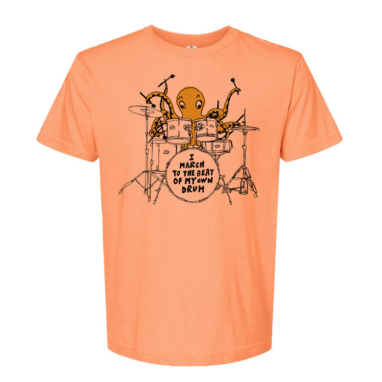 An orange t-shirt with a graphic design depicting an octopus playing a drum set, accompanied by the text "I MARCH TO THE BEAT OF THE DRUM".