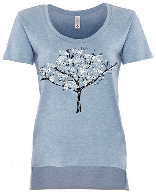 A light blue t-shirt with a graphic design of a tree with white flowers on it.