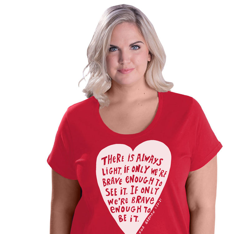 A woman wearing a red t-shirt with a heart-shaped design and text printed on it.