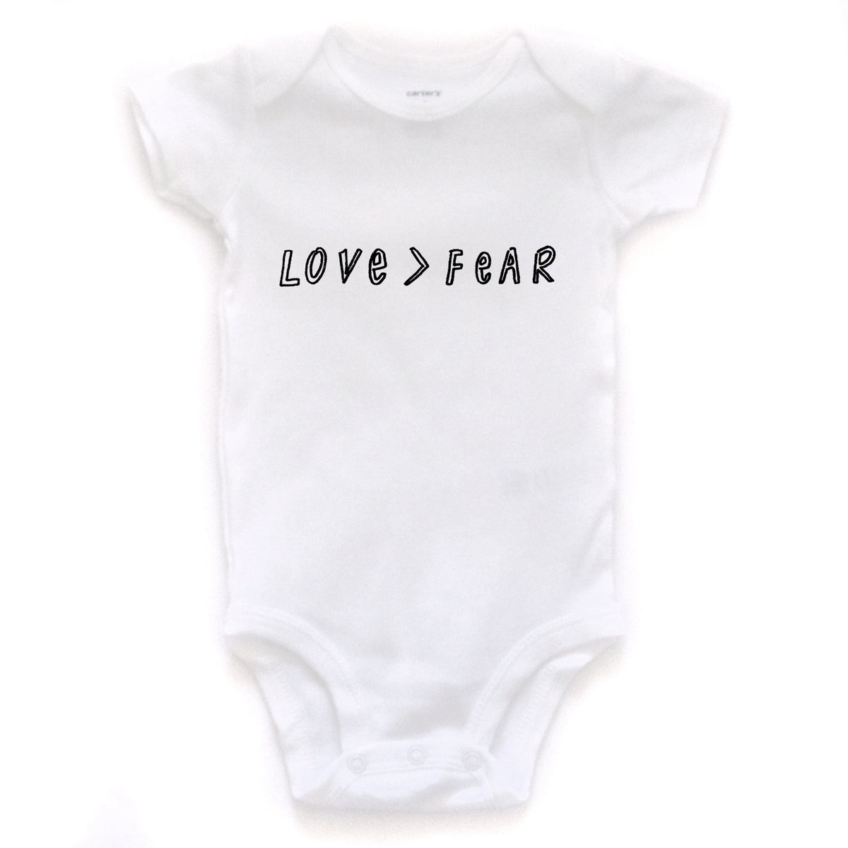 A white baby onesie with the text "LOVE > FEAR" printed on it.