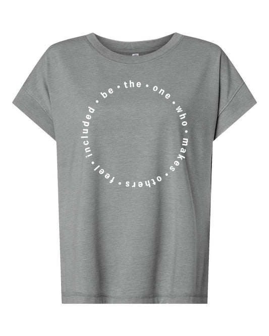 A gray t-shirt with a circular design featuring the text "be the one who makes others feel free" printed on it.