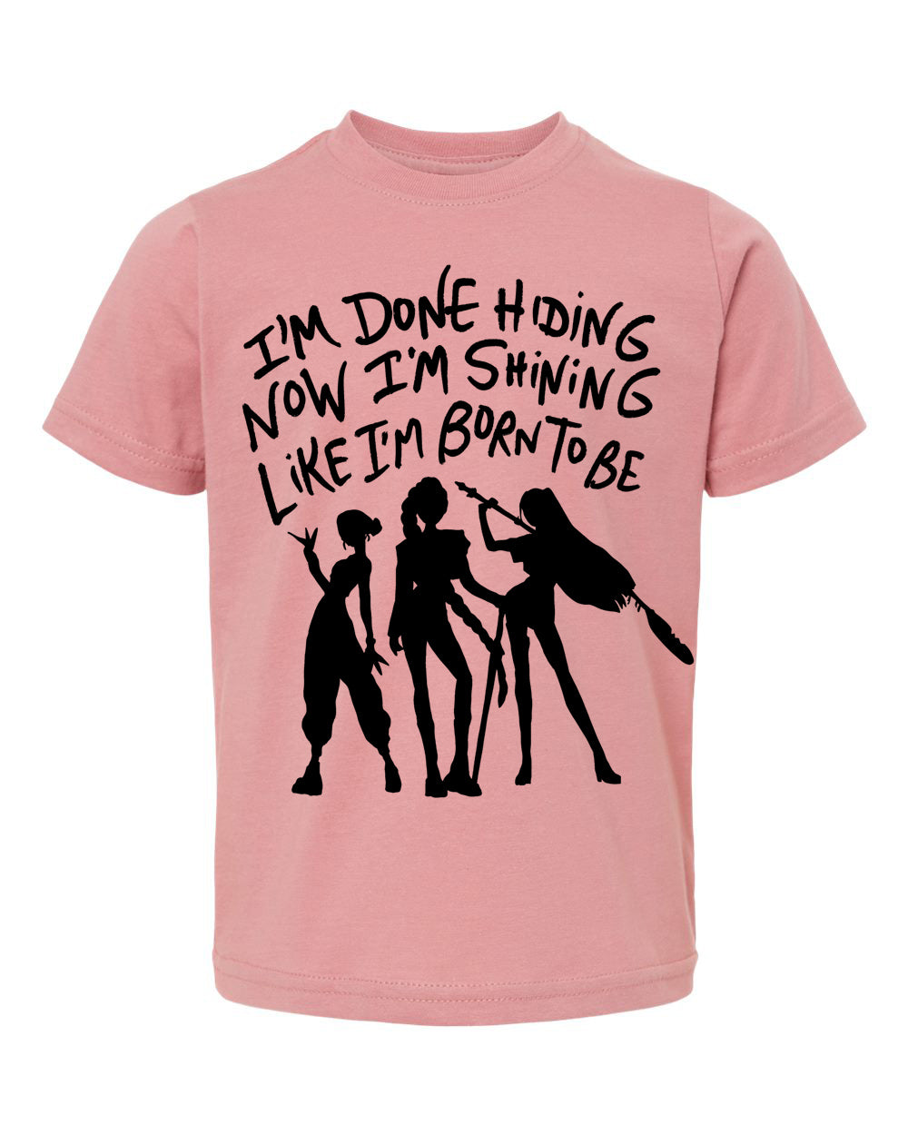 A pink t-shirt with a graphic design featuring silhouettes of three people and text that reads "I'm done hiding now I'm shining like I'm born to be".