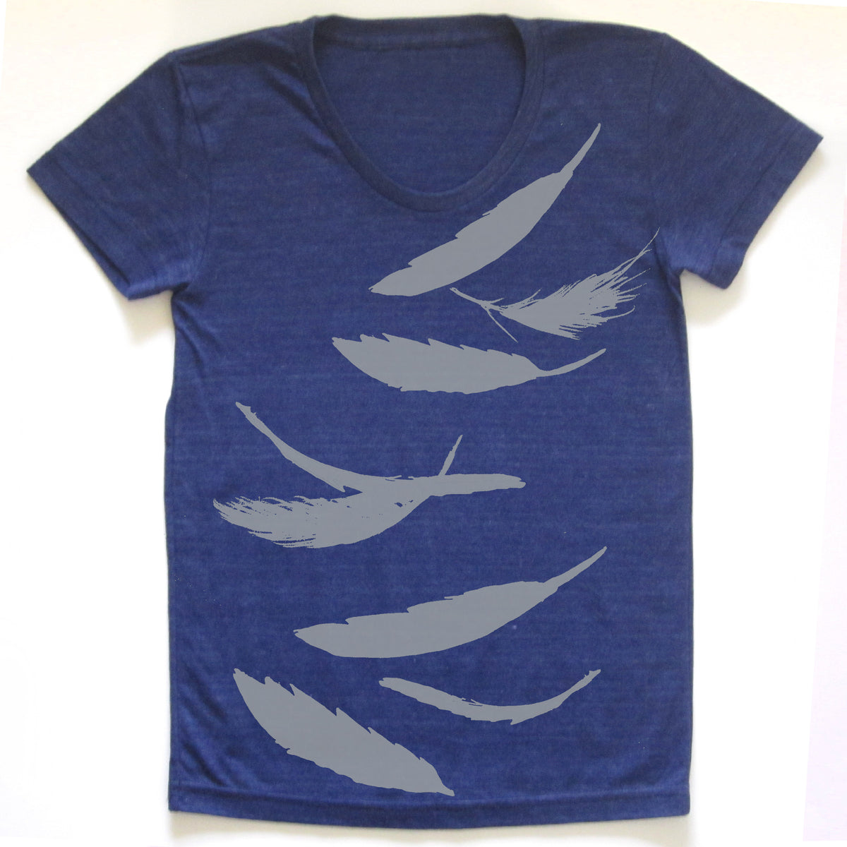 A blue t-shirt with a graphic design of white silhouettes of feathers.